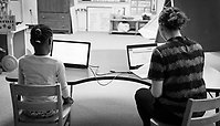 Elev och lärare arbetar vid datorer.