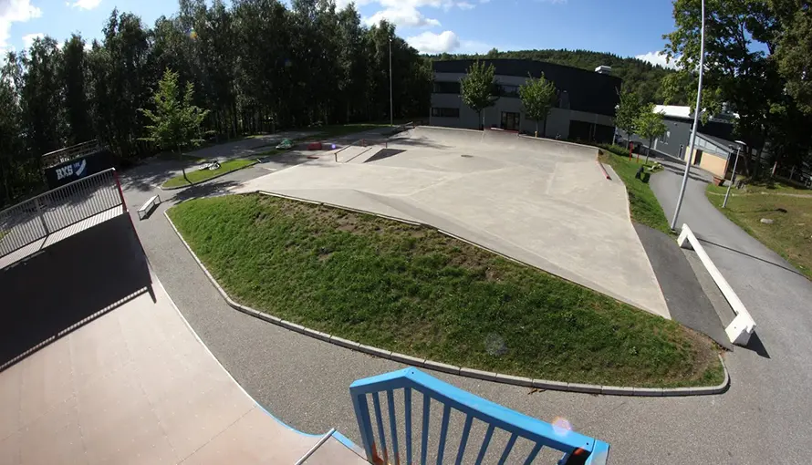 Betongen parken fotad från ett skateboardhinder mot Skatehallen.
