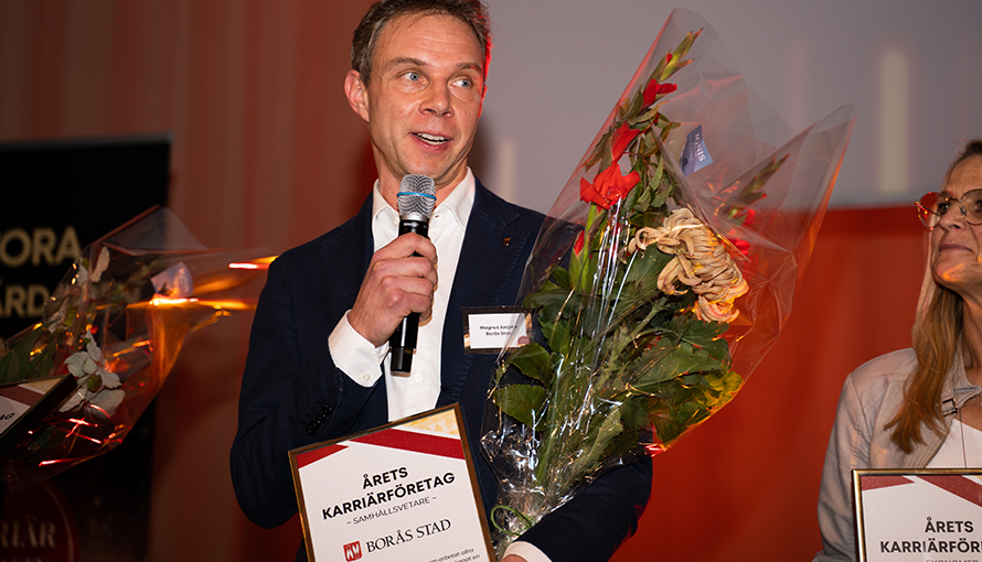 HR-strateg Magnus Andrén med blommor och diplom med texten Årets karriärföretag i kategorin samhällsvetare. 