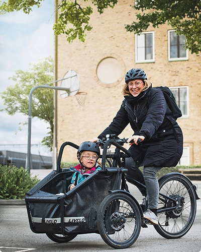 En kvinna och ett barn på en cykel.