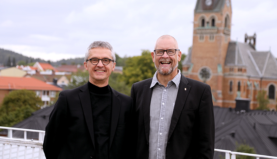 Foto på två män, Per och Jonas, stående på ett tak med utsikt över Borås.