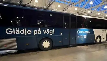 Stor buss som det står Glädje på väg på