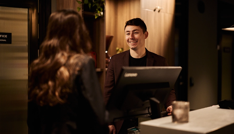 APL-handledare (hotell) och elev står i receptionen. 