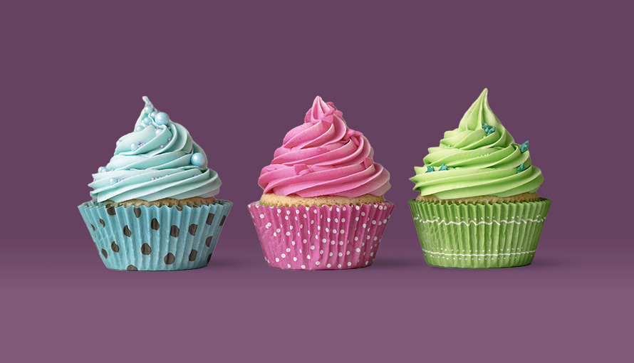 Tre cupcakes med blå, rosa och grön frosting.
