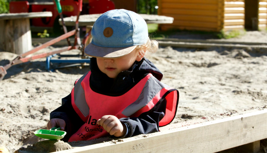 Ett barn leker i sandlådan. 
