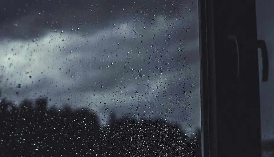 Tunga regnmoln visade genom ett regnstänkt fönster.