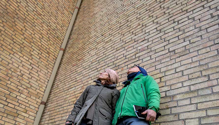 Agnes Nagy och Peter Serrander tittar på tegelväggen. Foto: Anna Sigge.