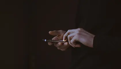 En hand som håller i en mobiltelefon 