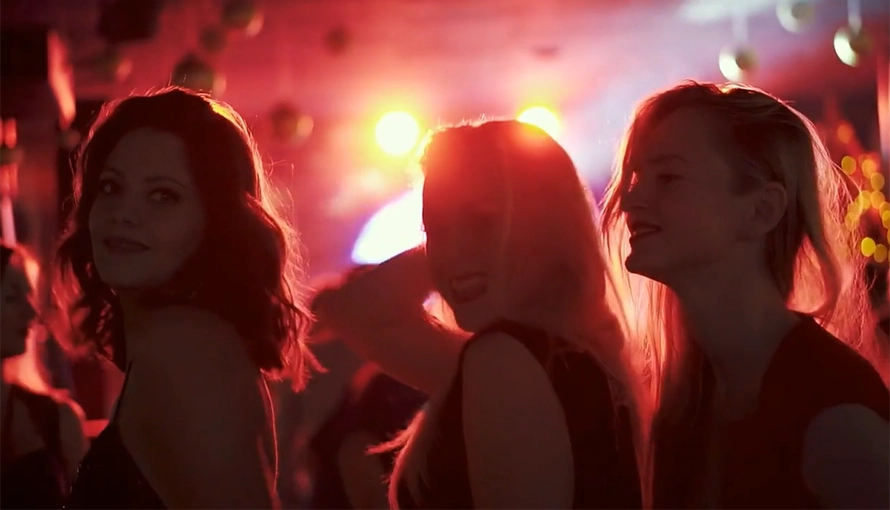 Tre tjejer som dansar i en festlokal