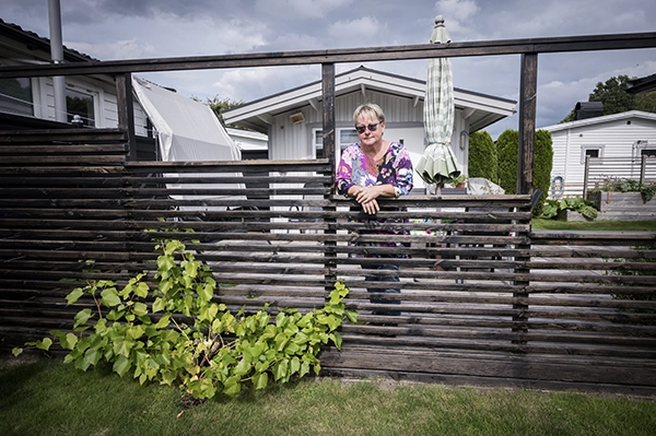 Ann-Marie Hagström hänger på ett staket vid sin sommarstuga.