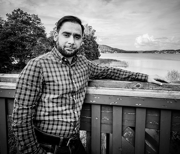 Taimur Khan står på en bro vid en sjö med ena armen på räcket.