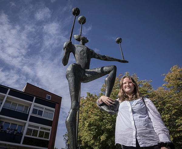 Linnéa Wilhelmsson håller i foten på statyn som står vid Sjöbo torg.