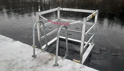 Vinterbad vid en brygga med stege och staket