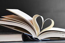En öppen bok vars blad bildar ett hjärta