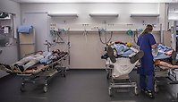 Tre skademarkörer (personer som sminkats för att simulera att de är skadade) ligger i sjukhussängar och vårdas av en vårdpersonal. 