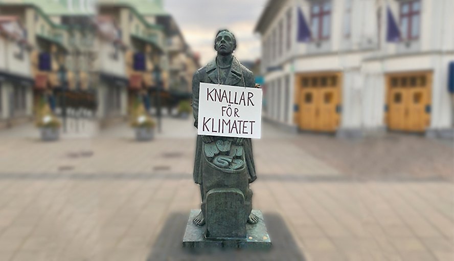 En knalle-staty med en skylt runt halsen. På skylten står det "Knallar för klimatet".