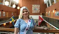 Valledare Anna Freidlitz fotad på Stadshushallens balkong med valbanderoll över ena axeln