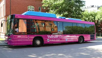 En stadsbuss som är dekorerade i rosa där det står Valbuss - här kan du rösta