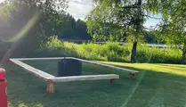 Grillplats på gräsmatta intill sjö