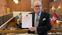 Per-Olof Höög, Kommunfullmäktiges ordförande, håller upp den undertecknade Deklaration för en stark demokrati. 