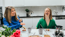 Två personer som skrattar vid ett köksbord